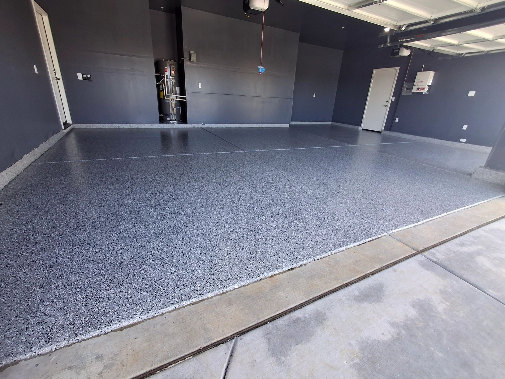 Finished dark-gray residential garage with speckled epoxy floor
