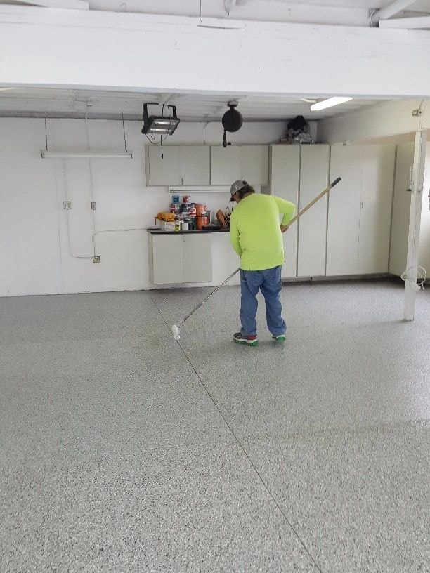 Installer applying a clear protective coat to a decorative epoxy floor